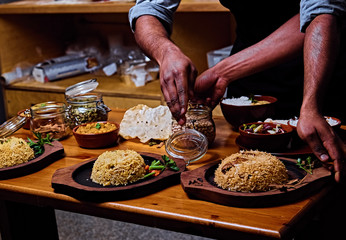 Indian male preparing Asian meals with rice in a kitchen.
