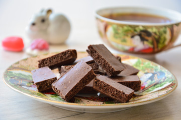 Black porous chocolate on a tea saucer