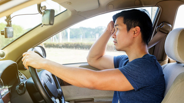 Asian Young Man Driving A Car And Feel Sleepy.