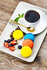 Photo of macaroons and berries on wooden background