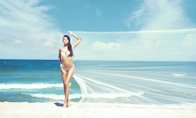 Young and beautiful woman in a swimsuit posing on a beach. Traveling, holiday, concept.