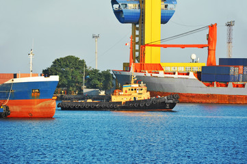 Tugboat assisting container cargo ship