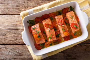Delicatessen food: salmon fillet baked with tomatoes and rosemary. horizontal top view
