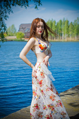 Fototapeta na wymiar Fantastic redhead young woman dancer with pale skin оn nature in colorful dress with stones. Attractive girl around water and garden relaxing in scenic oriental Arabic costume 