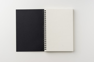 Business concept - Top view of spiral blank notebook on white background desk for mockup