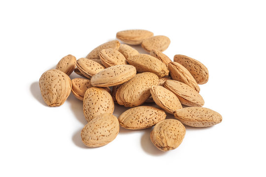 A lot of almond nuts in the shell isolated on white background, selective focus
