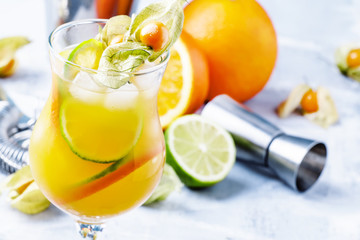 Alcoholic cocktail summer breeze with syrup, lime, orange, beer and ice, selective focus