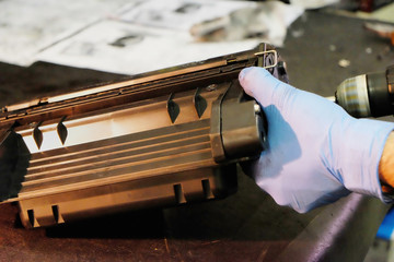 worker in the shop repairing a broken laser cartridge.