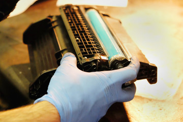 worker in the shop repairing a broken laser cartridge.
