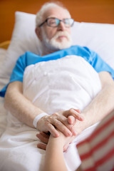 senior patient holding hands