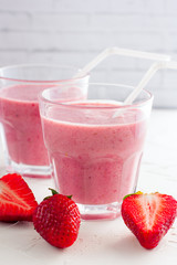 Iced strawberry pink cocktail in a glass and strawberries