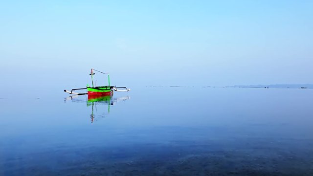Video footage of beautiful landscape of a calm lake with a fisherman boat