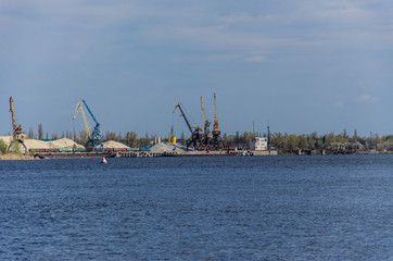 Fototapeta na wymiar Cranes in cargo port on a river Dnieper in Kremenchug, Ukraine