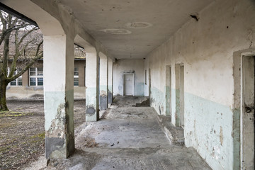 Old abandoned building with pillars and a porch in the village