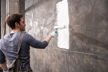 young man painting wall, renovation home concept