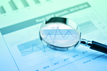 Rise graph with magnifying glass over financial chart, Business analysis concept
