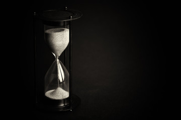 Large black hourglass against a black background