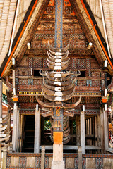 Part of tongkonan house with horns of buffaloes and wood carving and paintings, traditional torajan buildings. Ethnic village Kete Kesu in Tana Toraja, Rantepao, Sulawesi, Indonesia. Wide angle © linortis
