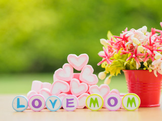 mother's day concept.  LOVE MOM alphabet with marshmallow in the shape of heart and flower on background