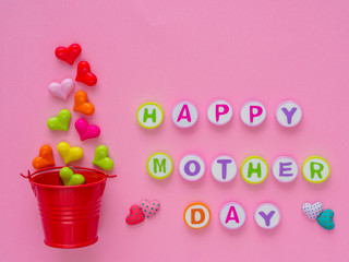 mother's day concept.  HAPPY MOTHER DAY alphabet with colorful heart and red bucket on blue background