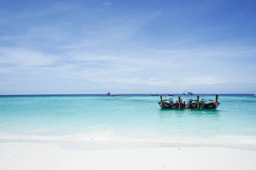 relaxation concept of long tail boats float on the clear blue sea taken at Lipe Island, Satun, Thailand on 8 April 2017