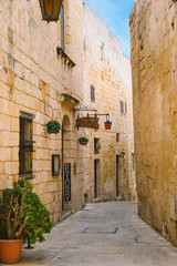 Narrow street of Silent City with a small restaurant, Mdina, Malta