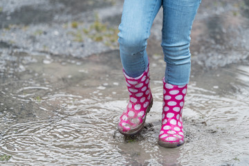 Gumboots splashing through a rain puddle