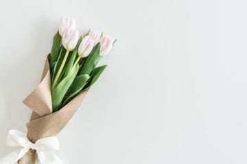 light pink tulips bouquet in kraft paper isolated on white with copy space, wedding flowers background concept