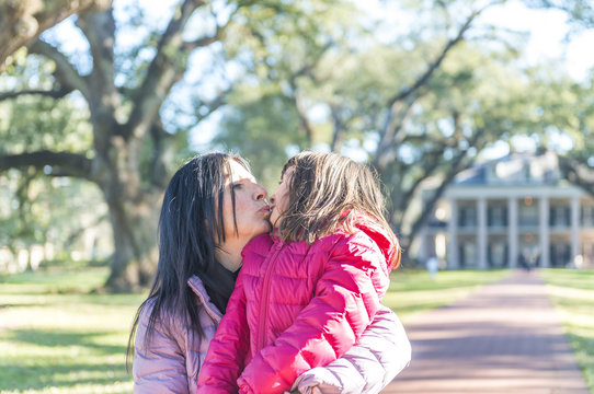 Mother and daughter kissing on a beautiful park
