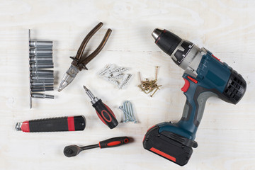 Acu drill screwdriver rachet and tools flat lay over wooden background