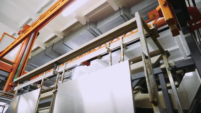 Manufacture. Process of anodizing aluminum products  in production, Immersion of aluminum plates in liquid. Automatic production line.  4k footage. 
