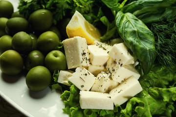 Olives, brynza and greens on a plate,Fresh salad with bryndza, olives,plate of soft cheese (feta and bryndza),Green olives in the bowl
