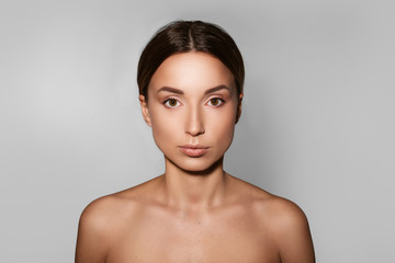 Natural beauty. Portrait of a brunette woman looking at the camera while standing on a white background