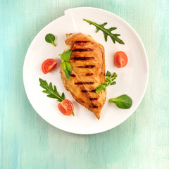 Grilled chicken fillet with cherry tomatoes and salad leaves