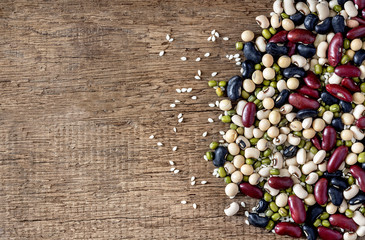 mix of beans on wood table. green bean, soybean, black bean ,red bean and White kidney bean