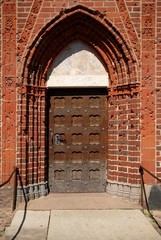 Old wooden door with brick arch facade