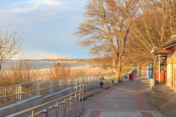 Ustka na polskim pomorzu. Nadmorska promenada oświetlona zachodzącym słońcem