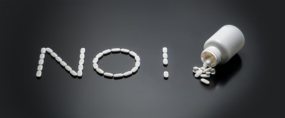 No drugs or stop using a medicine concept with pills spilled on table from bottle. Anti doping in...