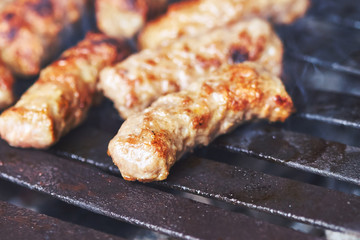Cevapi (cevapcici) on grill.  Grilled dish of minced meat, found traditionally in Balkan cuisine