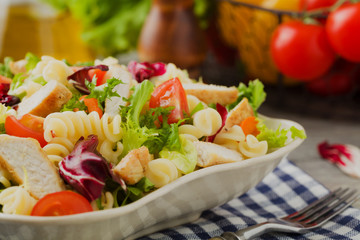 Noodle salad with green lettuce, tomatoes and roasted chicken.