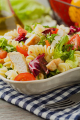 Noodle salad with green lettuce, tomatoes and roasted chicken.