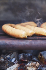 Sausages on grill with smoke and charcoal. Copy space