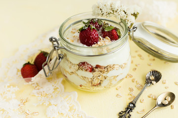 Oatmeal with strawberries and coconut on a yellow background (close-up).