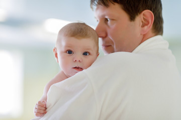 Young father and his little cute newborn baby daughter together in spa hotel.