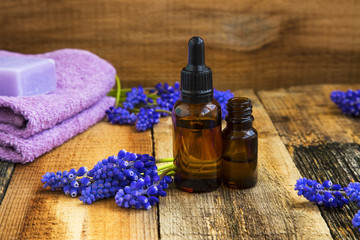 Obraz na płótnie Canvas Spa set with aromatherapy oils bottles and purple flowers on wooden background