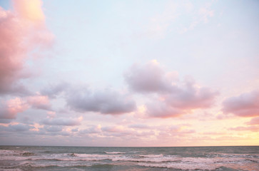 Lazurowe różowe chmury nad morzem o zachodzie słońca - 147914313