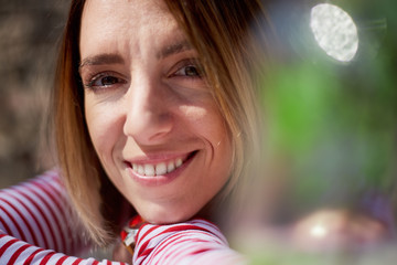 smiling woman siting in garden. close up