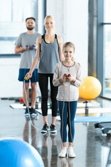 Young fitness people exercising with skipping ropes at sports center