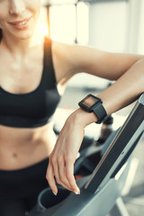 Young attractive woman resting after workout on treadmill