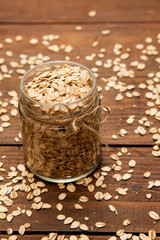 Oatmeal in a glass jar. Wooden background